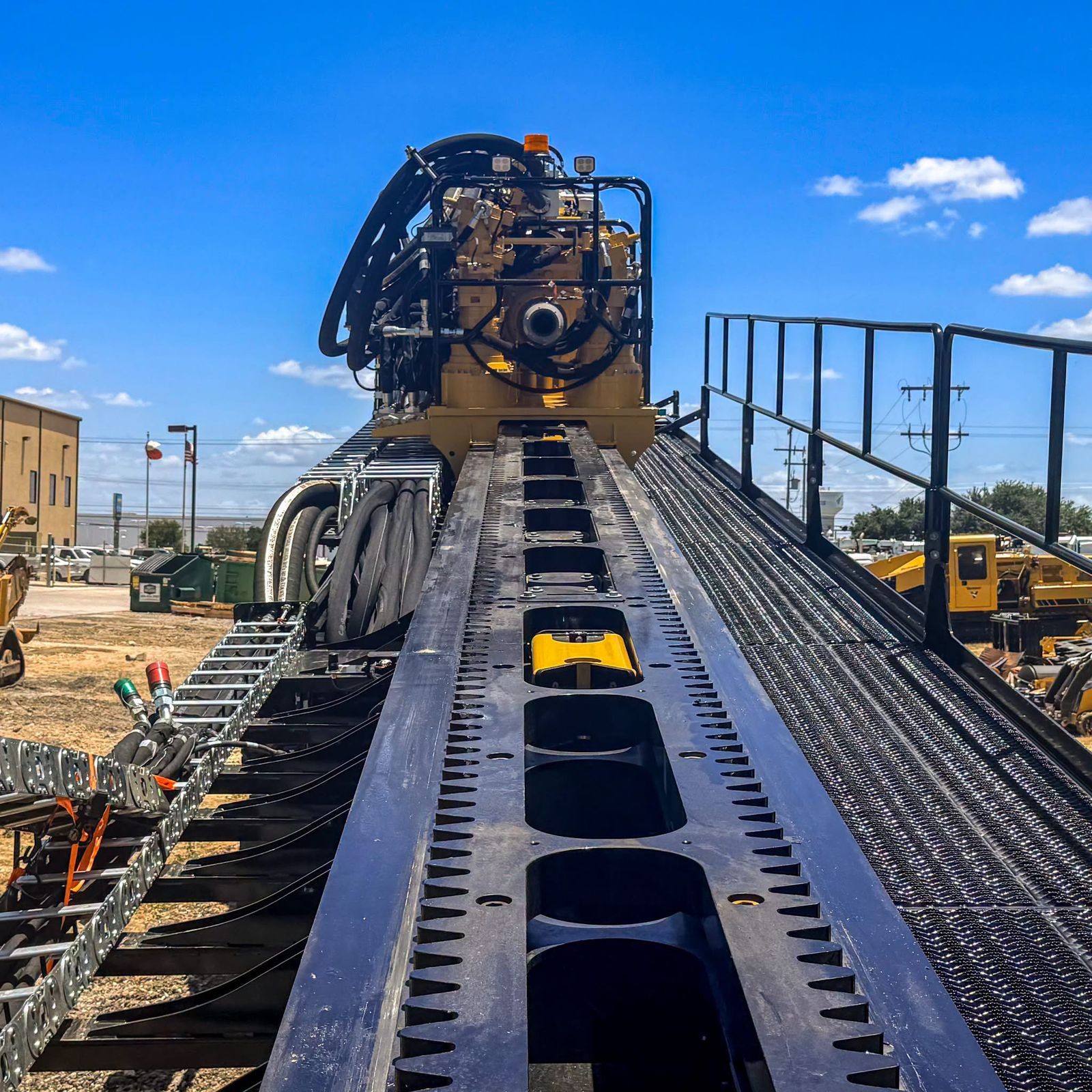 Pipe jacking rig installed on rails ahead of a bore