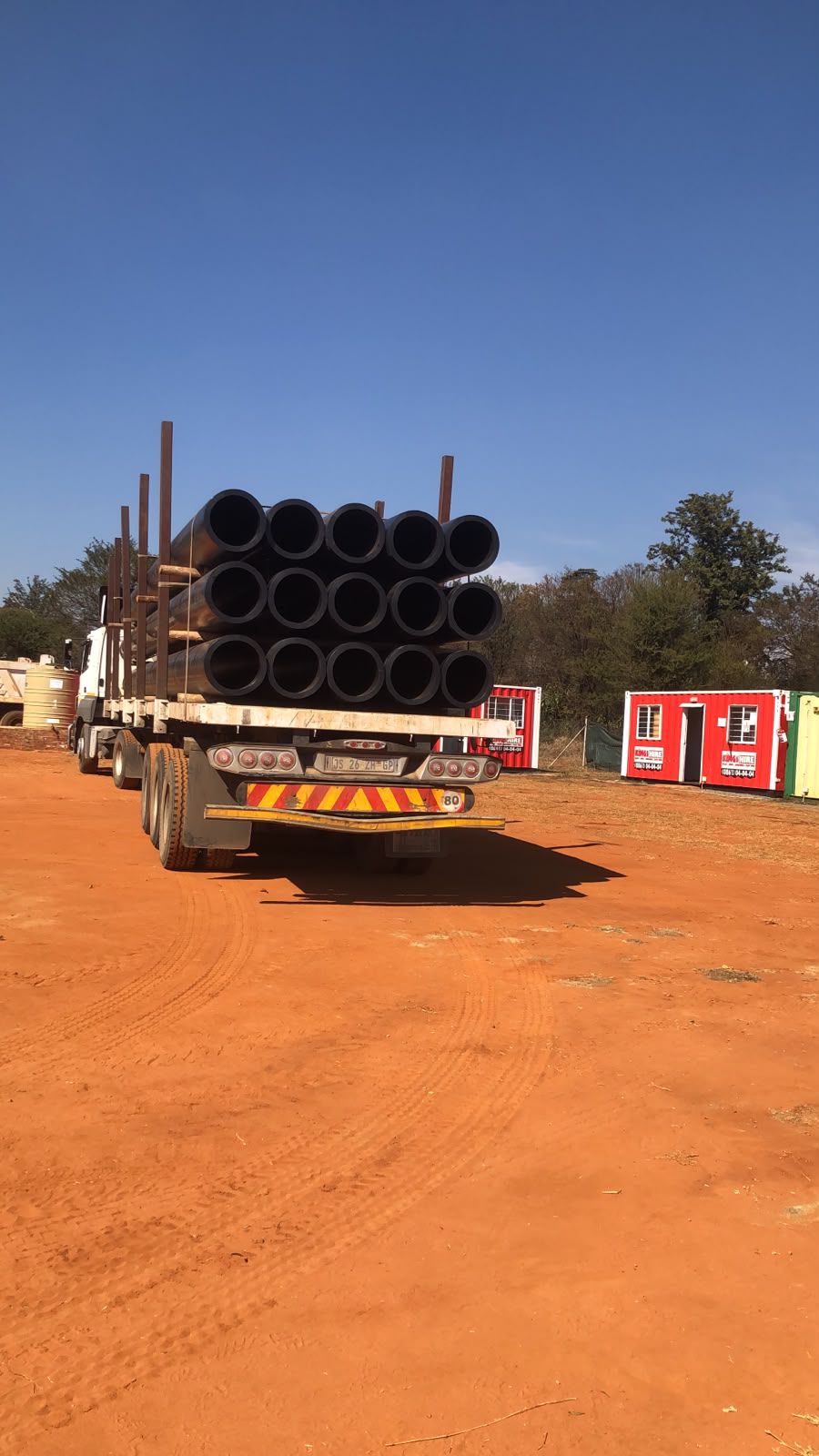 Truck loaded with large HDPE pipes arriving on site